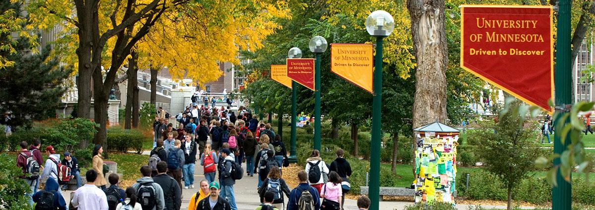 students walking on Northrop Mall with fall leaves